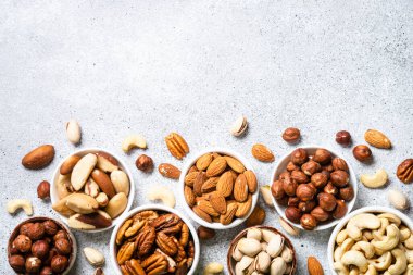 Fındık çeşitleri kaselerde. Ceviz, fındık, ceviz, badem, Brezilya fındığı ve şam fıstığı. Kopyalama alanı olan üst görünüm.
