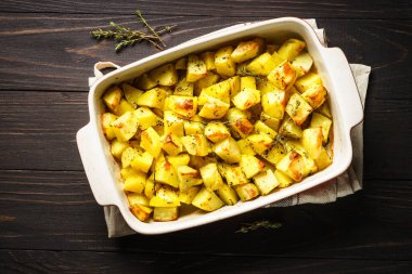 Koyu kırsal masada kekikli fırında patates. vejetaryen yemeği.