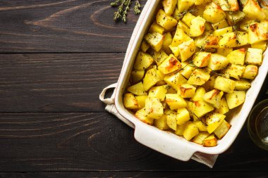 Koyu kırsal masada kekikli fırında patates. vejetaryen yemeği.