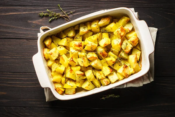 Koyu kırsal masada kekikli fırında patates. vejetaryen yemeği.