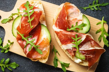 Krem peynirli sandviç, jambon, salatalık ve roka. Üst görünüm, kapat.