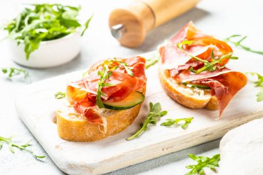 Aperatif crostini, krem peynirli sandviç, prosciutto, salatalık ve roka..