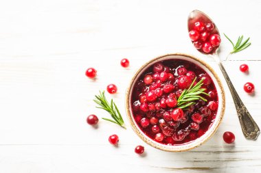Beyaz ahşap masadaki bir kasede kızılcık sosu. Metin için boşluk olan üst görünüm.