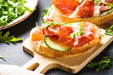 Aperatif crostini, krem peynirli sandviç, jambon, salatalık ve roka..