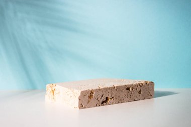 Kozmetik ürünleri sunumu için taş podyum. Palmiye yaprakları gölge.