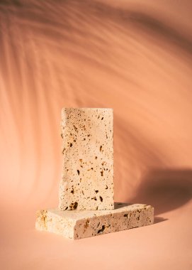 Bej arka planda gölgeli kozmetik ürünlerin sunumu için travertin podyumu.