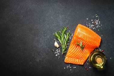 Çiğ somon, siyah arka planda taze balık filetosu. Üst Manzara. Yemek yapmaya hazır..
