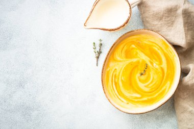 Taş masadaki el işi kasesinde balkabağı çorbası. Kopyalama alanı olan üst görünüm.