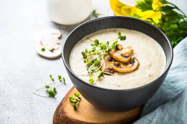 Siyah kasede mantar çorbası, aydınlık taş masada..