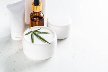 Esrar kozmetik ürünleri. Doğal kozmetik konsepti. Krema, sabun, serum, gerekli yağ ve taze kenevir yapraklı diğerleri..