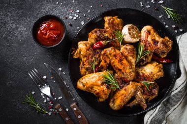 Siyah masada baharatlı ızgara tavuk kanadı. Tasarım için alanı olan üst görünüm.