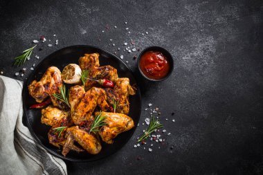 Siyah masada baharatlı ızgara tavuk kanadı. Tasarım için alanı olan üst görünüm.