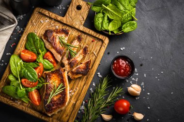 Tahta tahtada servis edilen taze salatalı domuz eti bifteği. Siyah tabloda en üstteki resim.