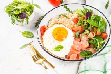 Beyazda tuzlu kahvaltı. Tuzlu somon, yumurta ve taze salata ile yulaf ezmesi..