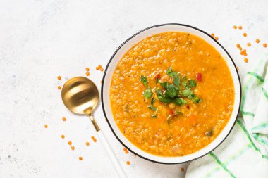 Lentil soup with vegetables at white stone table. Traditional turkish or arabic dish. Top view with copy space. clipart