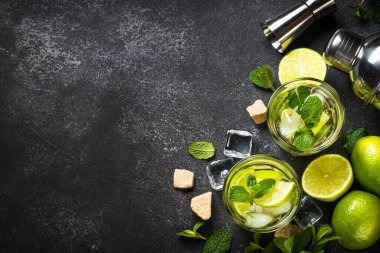Siyah taş kaplamalı mojito kokteyli. Limonlu, romlu, naneli ve buzlu mojito. Üst görünüm kopyalama alanı.