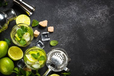 Siyah taş kaplamalı mojito kokteyli. Limonlu, romlu, naneli ve buzlu mojito. Üst görünüm kopyalama alanı.