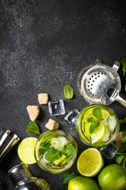 Siyah taş arka planda mojito kokteyli. Limonlu, romlu, naneli ve buzlu mojito. Üst görünüm kopyalama alanı.