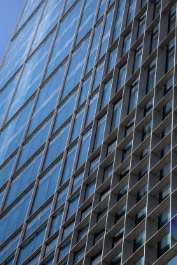 Gökdelen. Gökdelen mavi gökyüzüne karşı. Büyük bir şehirde cam ve metal bina, ofis ve iş merkezi.