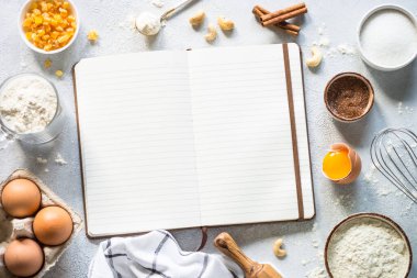 Pişirme kitabı ve malzemelerle yemek pişirme geçmişi. Un, şeker, yumurta ve çatal bıçak. Kopyalama alanı olan üst görünüm.
