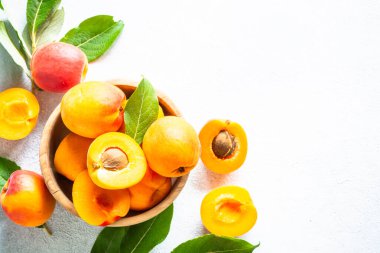 Apricots with green leaves at white background. Fresh fruit.