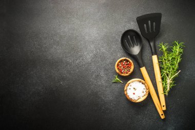 Kitchen utensils with food ingredients on black. Food background. Top view with copy space.