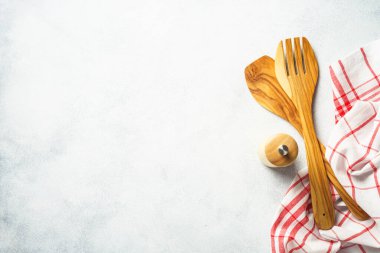 Kitchen utensil and tablecloth on white stone table. Top view with copy space.