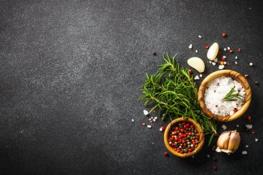 Ingredients for cooking on black stone kitchen table. Herbs, spices and vegetables. Flat lay.