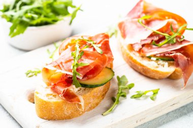 Aperatif crostini, krem peynirli sandviç, prosciutto, salatalık ve roka..