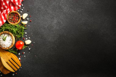 Food background on black. Herbs, spices and utensil. Top view with space for text.