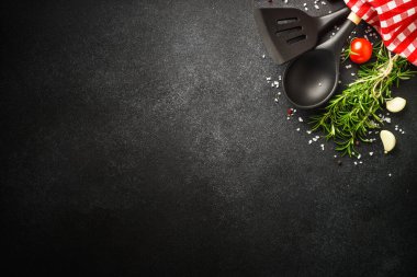 Food background on black. Herbs, spices and utensil. Top view with space for text.