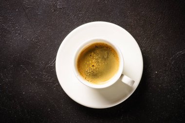 Coffee cup. espresso in white cup at dark table. Top view image.