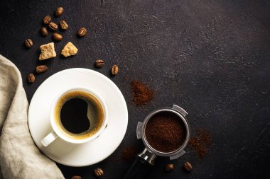 Coffee cup and coffee beans at dark table . Top view image with copy space.
