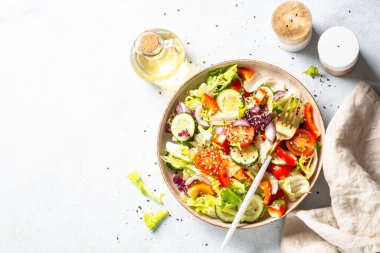 Fresh salad with green leaves, cucumber, paprika and tomatoes. Flat lay.