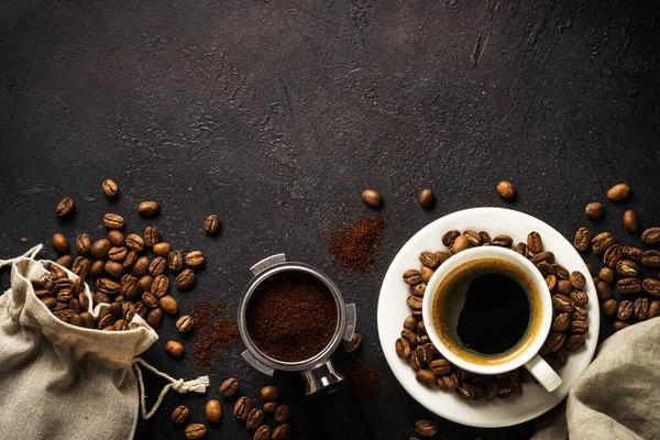 ダークテーブルでコーヒーカップとコーヒー豆 コピースペース付きのトップビュー画像 — ストック写真