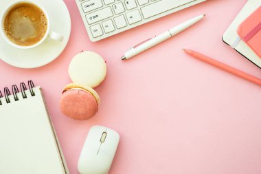 Home office workspace. Pink flat lay office desk with keyboard, notebook and coffee cup..