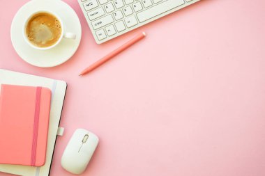 Office workspace. Woman flat lay pink office desk with keyboard, notebook and coffee cup..