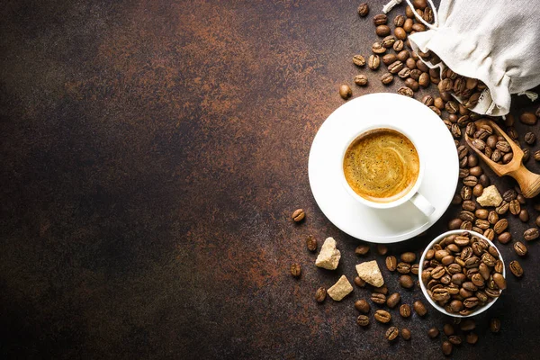 暗いテーブルでコーヒー ローストコーヒー豆と砂糖のカップ コピースペース付きのトップビュー画像 — ストック写真