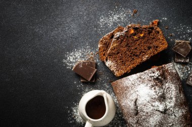 Chocolate cake with oranges. Homemade baking. Top view on black.