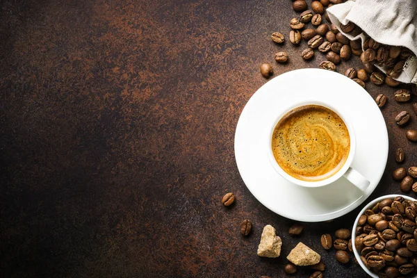 黒石のテーブルでコーヒーとローストコーヒー豆の袋のカップ コピースペース付きのトップビュー画像 — ストック写真