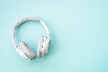 Wireless Headphones on blue background. Flat lay with copy space.