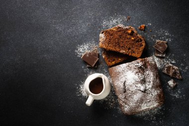 Chocolate cake with orange slices. Homemade baking on black background. Top view with copy space.