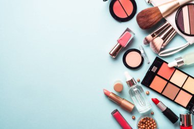 Make up cosmetics on blue background. Flat lay with copy space.