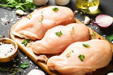 Tahta kesme tahtasındaki baharatlı tavuk göğsü. Kapat..