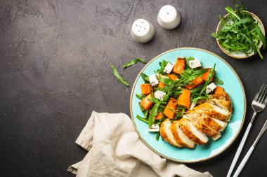 Fırında tavuk göğsü, balkabağı, mavi peynir ve roka ile sıcak salata. Dash diyeti, keto diyeti. Kopyalama alanı olan üst görünüm.