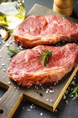 Beef steak with spices. Raw beef meat at cutting board. Close up.