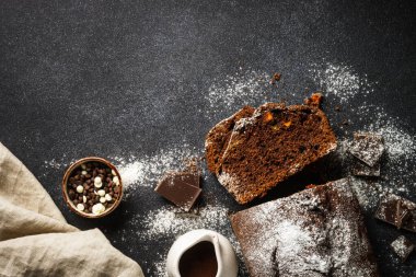Chocolate cake with oranges. Homemade baking. Top view on black.