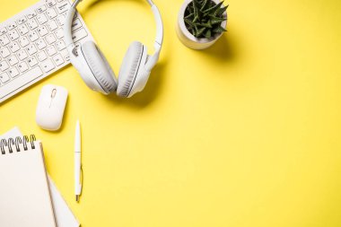 Office desk with laptop, headphones, notepad and pen. Flat lay image with copy space. Office, studying, workspace.