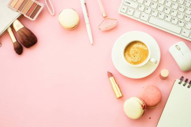 Home office workspace. Creative Pink flat lay background with keyboard, notebook, coffee cup and cosmetics..