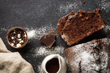 Chocolate cake with oranges. Homemade baking. Top view on black.